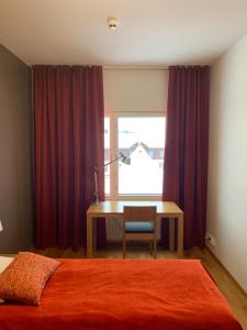 a bedroom with a bed and a desk and a window at Ruka Chalets 1304 high quality apartment in Kuusamo