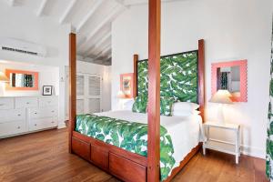 a bedroom with a four poster bed with green sheets at Montpelier Nevis in Nevis
