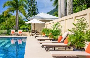 a row of lounge chairs next to a swimming pool at Montpelier Nevis in Nevis