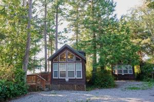 a small cabin in the middle of a forest at La Conner Camping Resort Cabin 7 in La Conner