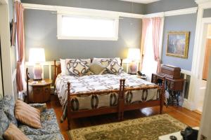 a bedroom with a bed and a couch and a window at The Coolidge Corner Guest House: A Brookline Bed and Breakfast in Brookline