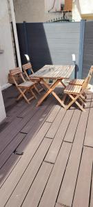 two chairs and a picnic table on a deck at Maison game in Villeneuve-sous-Dammartin