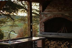 a kitchen with a brick oven with a sink and a window at Vikendica Pino in Han Pijesak