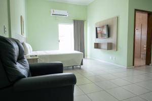 a living room with a couch and a bath tub at Hotel Equinocios Executive in Barcarena