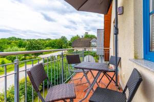a balcony with two chairs and a table on a balcony at Ferienwohnung Katharina OG in Wohlenberg