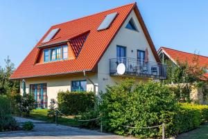 a white house with an orange roof at Ferienwohnung Katharina OG in Wohlenberg