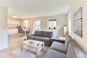 a living room with a couch and a table at Der Wattläufer in Ockholm