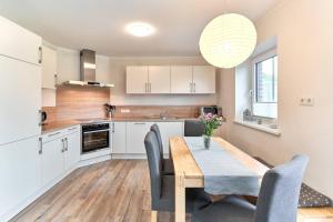 a kitchen and dining room with a wooden table and chairs at Der Wattläufer in Ockholm