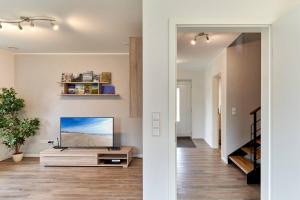 a living room with a flat screen tv on a wall at Der Wattläufer in Ockholm