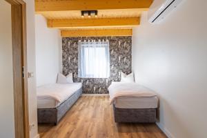 two beds in a small room with a window at PATIO APARTAMENTY in Łagów