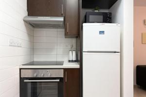 a kitchen with a white refrigerator and a stove at Old town studio in Limassol