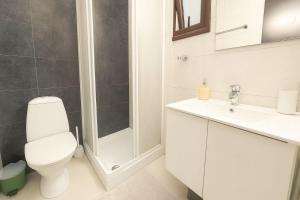a white bathroom with a toilet and a shower at Old town studio in Limassol