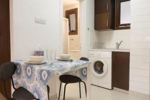 a kitchen with a table with chairs and a washing machine at Old town studio in Limassol +2 photos