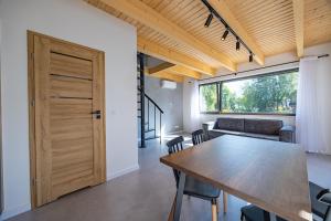 a dining room with a wooden table and a window at PATIO APARTAMENTY in Łagów