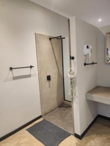 a shower stall in a bathroom with a sink at Charlen's Rest in Windhoek