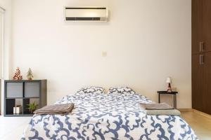 a bedroom with a bed with a blue and white comforter at Old town studio in Limassol