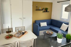 a living room with a blue couch and a table at Lambé in Pont-Aven