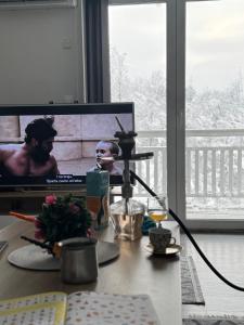 a desk with a computer monitor and a glass of wine at House Sarajka in Sarajevo