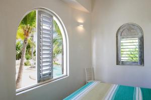 a bedroom with a window with a view of a palm tree at Casablanca Escape in La Majahua +91 photos