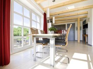 a dining room with a white table and chairs at Reethaus Ostseeblick 1 in Wohlenberg