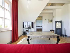 a living room with a table and a red curtain at Reethaus Ostseeblick 1 in Wohlenberg