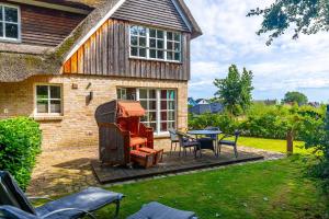 a patio with a table and chairs in front of a house at Reethaus Ostseeblick 1 in Wohlenberg +13 photos