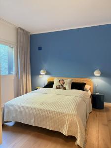 a bedroom with a large bed with a blue wall at See- & Bergblick Millstatt in Millstatt