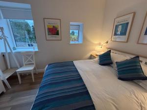 a bedroom with a large bed with blue pillows at Stable Cottage in Lockerbie