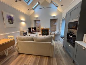 a living room with a couch and a fireplace at Stable Cottage in Lockerbie