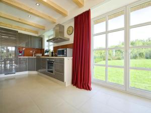 a kitchen with red curtains and a large window at Reethaus Ostseeblick 1 A in Wohlenberg