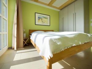 a bedroom with a bed in a room with green walls at Reethaus Ostseeblick 1 A in Wohlenberg