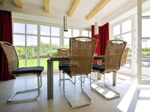 a dining room with a table and rattan chairs at Reethaus Ostseeblick 1 A in Wohlenberg