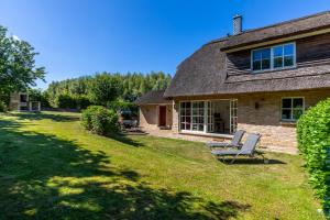 a house with a chair in the yard at Reethaus Ostseeblick 1 A in Wohlenberg