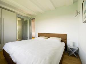 a bedroom with a large bed with white sheets at Reethaus Ostseeblick 1 A in Wohlenberg +19 photos