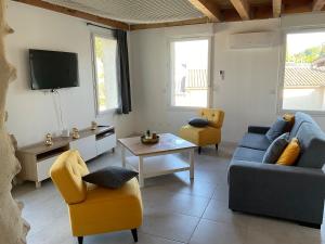 a living room with a couch and chairs and a tv at spacious cottage with hot tub in Saint-Martin-dʼArdèche