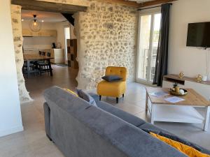 a living room with a blue couch and a yellow chair at spacious cottage with hot tub in Saint-Martin-dʼArdèche