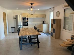 a kitchen and dining room with a wooden table and chairs at spacious cottage with hot tub in Saint-Martin-dʼArdèche +5 photos