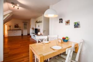 a dining room with a wooden table and white chairs at Strandhaus Lobbe, Mohnblume Nr 20 - Bade- & Saunawelt täglich inklusive in Middelhagen