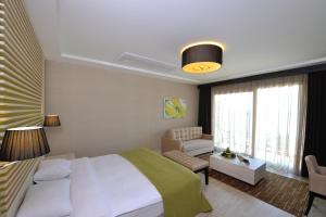 a bedroom with a bed and a chair and a couch at Sianji Well-Being Resort in Turgutreis