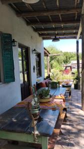a patio with a wooden table and benches on a porch at Casa De Campo El Corral in Carmen de Areco