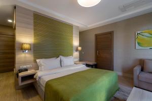 a hotel room with a large bed and a chair at Sianji Well-Being Resort in Turgutreis