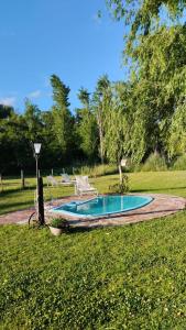 a small swimming pool in the middle of a yard at Casa De Campo El Corral in Carmen de Areco