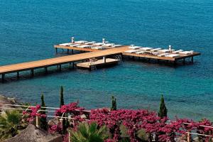 a dock in the water with tables and chairs on it at Sianji Well-Being Resort in Turgutreis