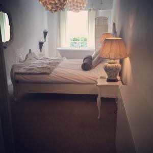 1 dormitorio con 1 cama con lámpara en una mesa en The Crown Inn, en Towcester