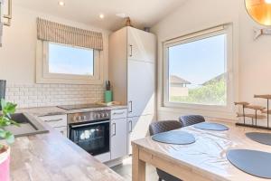 a kitchen with a table and a refrigerator at Wattkueken in Simonsberg