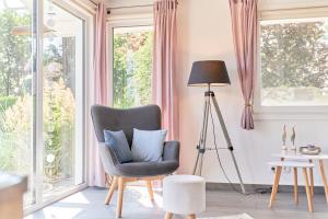 a living room with a chair and a lamp at Wattkueken in Simonsberg
