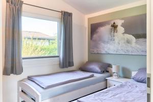 a bedroom with two beds and a window at Wattkueken in Simonsberg