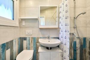a bathroom with a sink and a toilet and a mirror at Wattkueken in Simonsberg