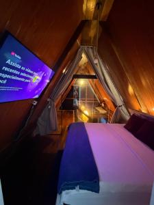 a room with a bed and a projection screen at Chalés El Profesor in Saubara