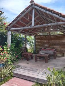 a wooden pergola with a couch and benches on a deck at Lo de Fabi in La Coronilla +20 photos